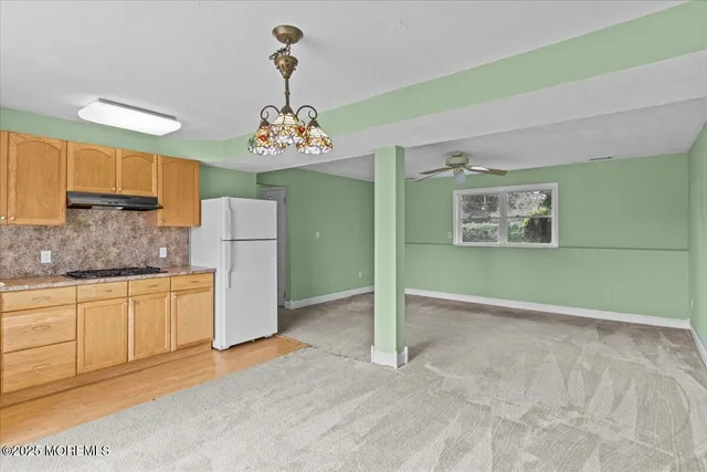 a kitchen with granite countertop a refrigerator and a stove top oven