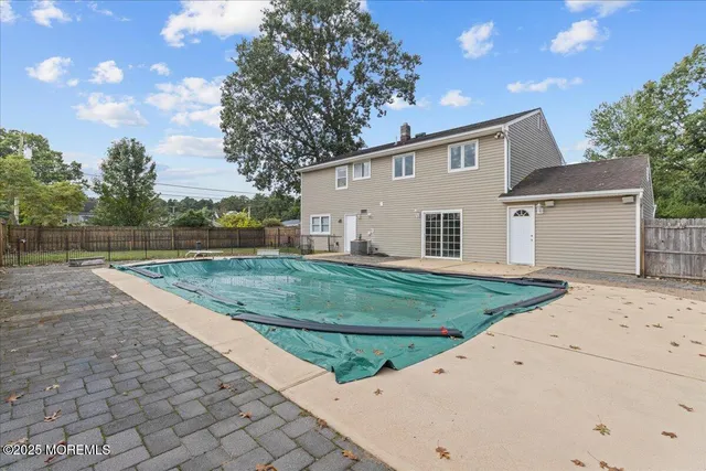 a view of a white house with a yard and large tree