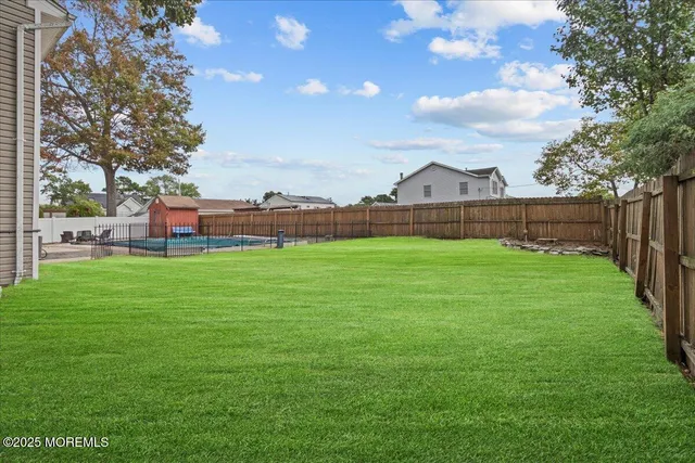 a view of a green field with house in the background