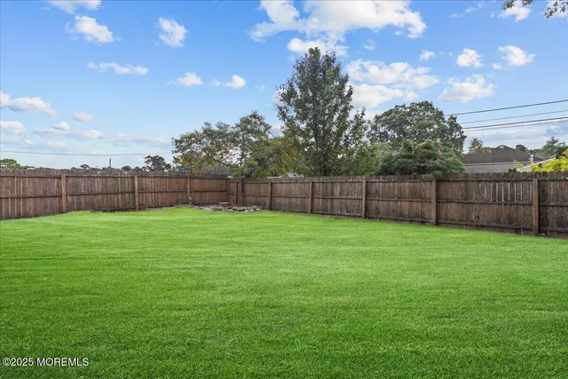 a view of a yard with a wooden fence