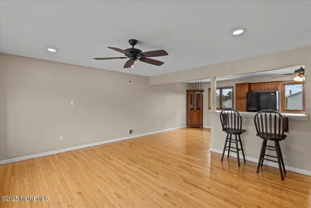 a view of room with wooden floor and windows