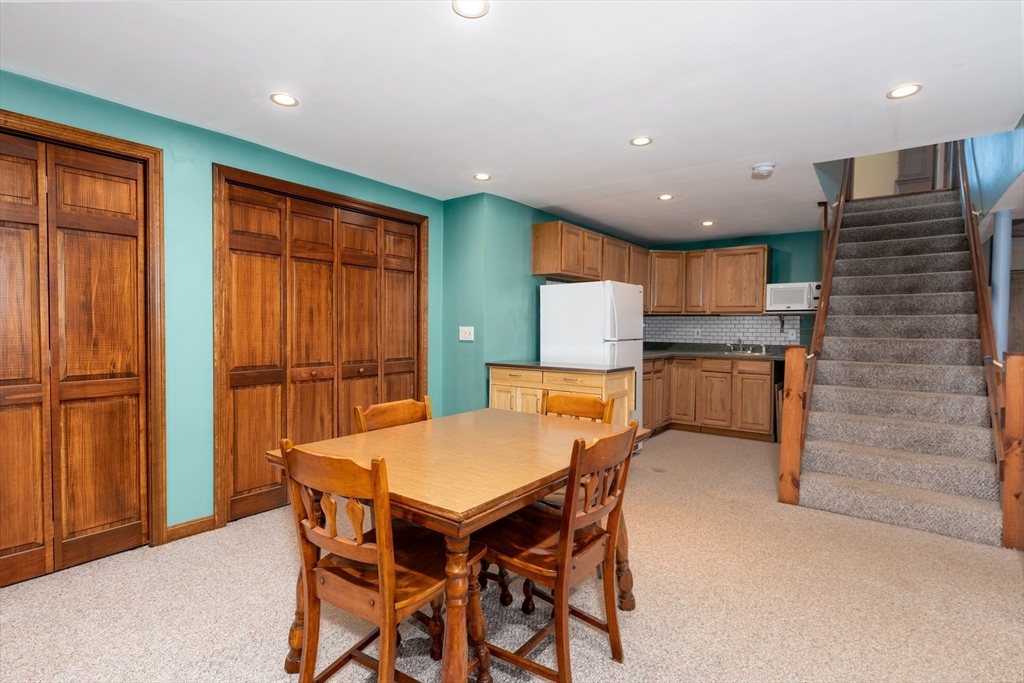 27 Dudley Road Sutton, MA 01590 - Photo 25 of 42 a kitchen with a table chairs refrigerator and cabinets