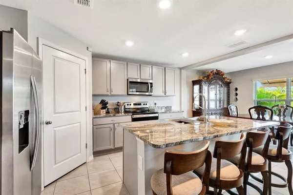 a kitchen with refrigerator cabinets dining table and chairs