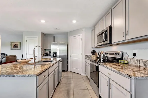 a kitchen with stainless steel appliances granite countertop a sink stove and refrigerator