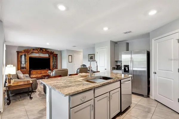 a kitchen with sink refrigerator and couch