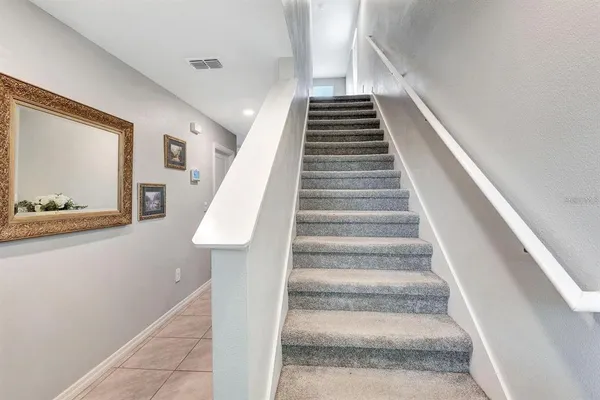 a view of staircase with white walls and a painting on the wall