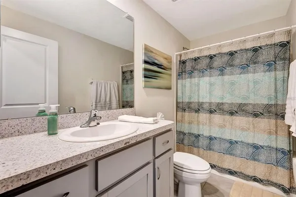 a bathroom with a granite countertop sink toilet and shower