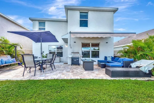 a view of a patio with table and chairs under an umbrella
