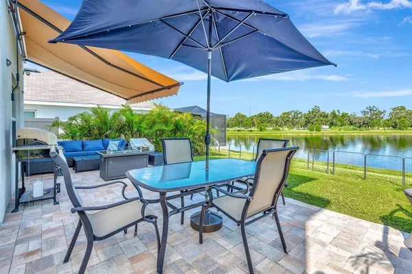 a patio with a table and chairs under an umbrella
