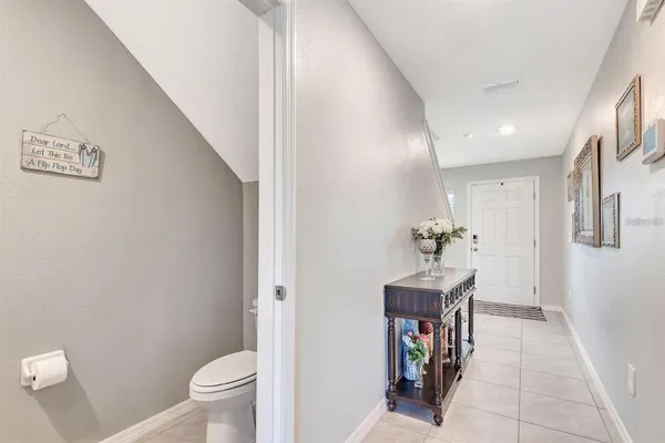 a view of a hallway with entryway wooden floor and a bathroom