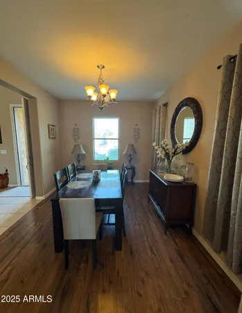 a living room with furniture a dining table and a chandelier