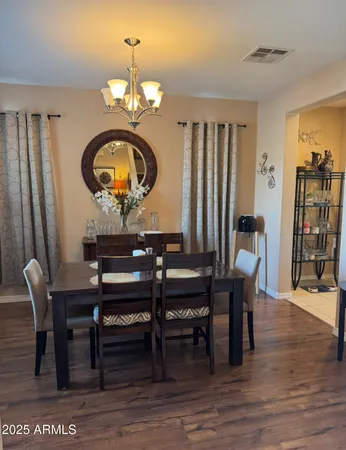 a dining room with furniture a chandelier and wooden floor