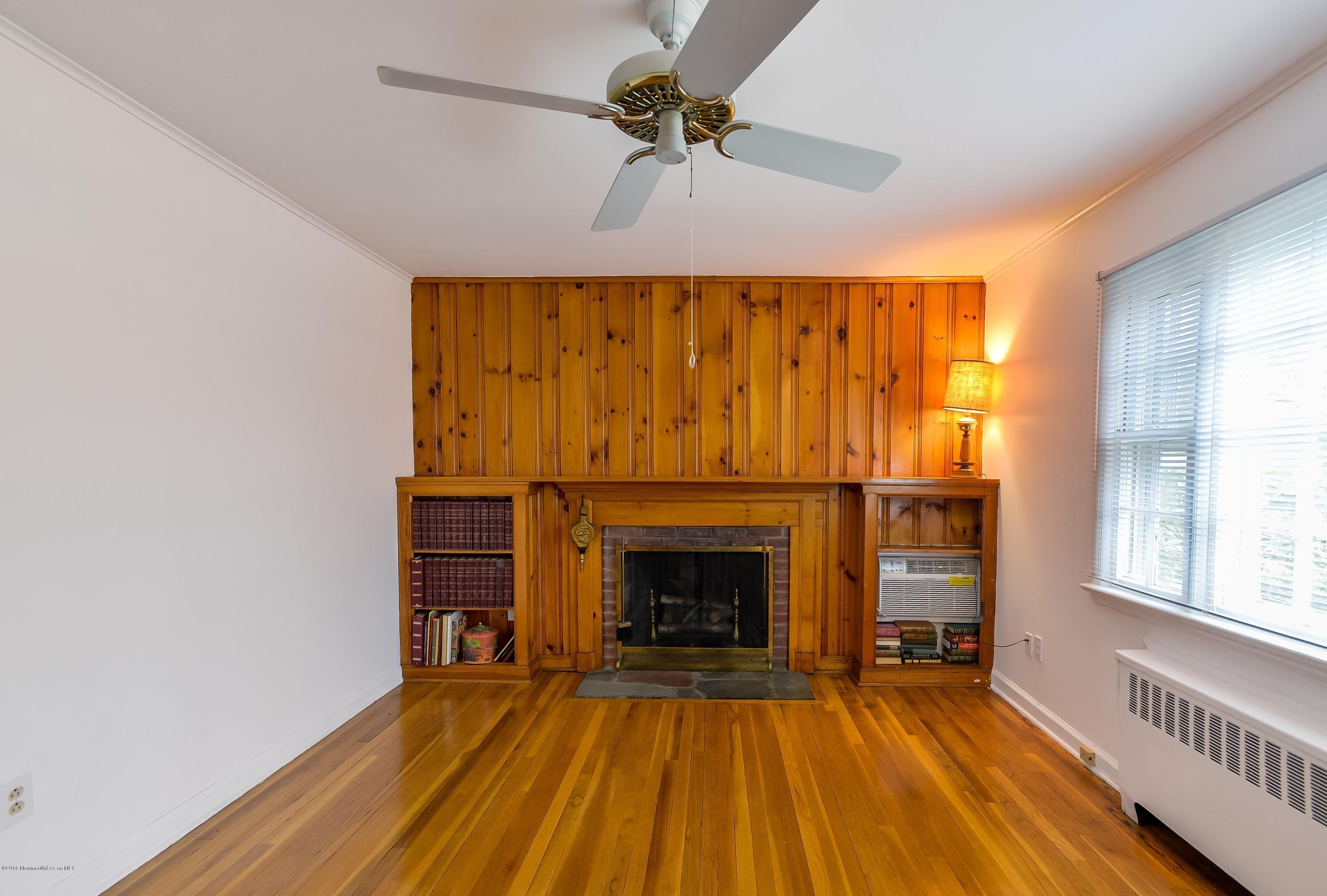 229 Pinecrest Road Oakhurst, NJ 07755 - Photo 2 of 12 a view of empty room with fireplace and wooden floor