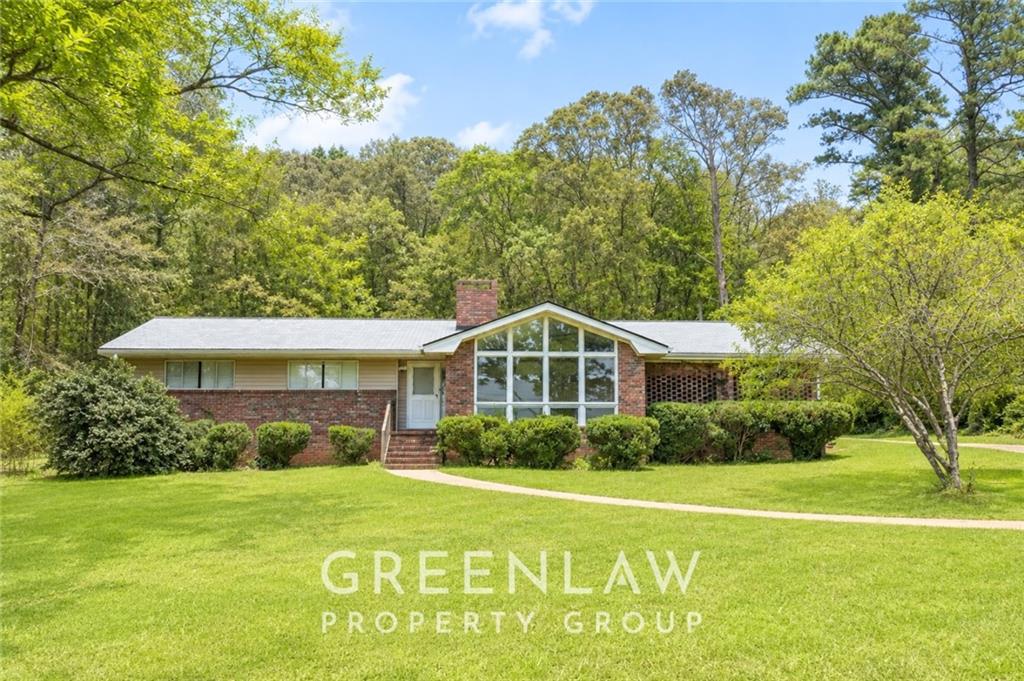 3605 Flat Shoals Road Atlanta, GA 30349 - Photo 1 of 35 a front view of a house with a yard