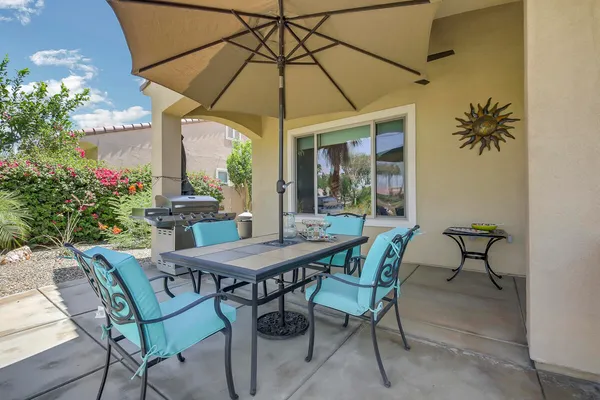 a patio with a table and chairs under an umbrella