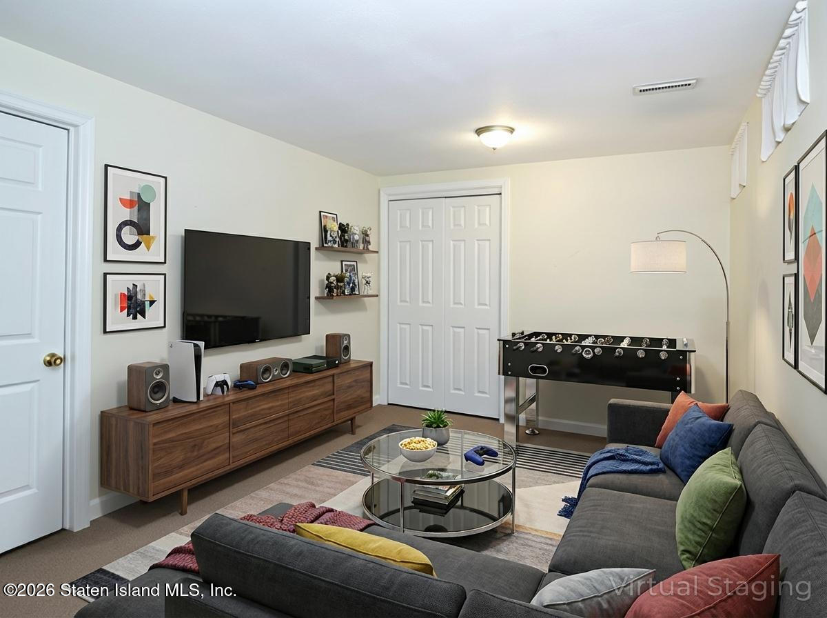 537 Willow Road East, Unit 1 Staten Island, NY 10314 - Photo 18 of 23 a living room with furniture and a flat screen tv