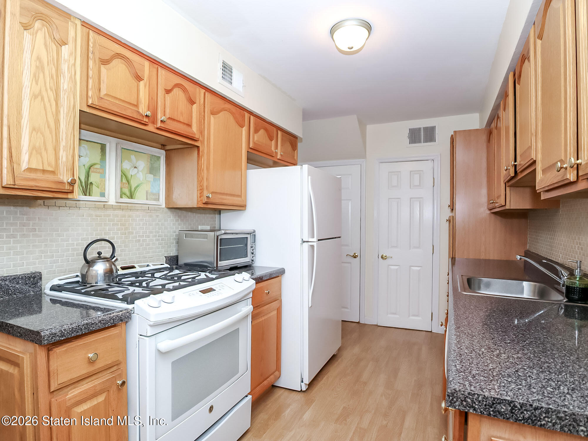 537 Willow Road East, Unit 1 Staten Island, NY 10314 - Photo 8 of 23 a kitchen with stainless steel appliances granite countertop a sink stove and refrigerator