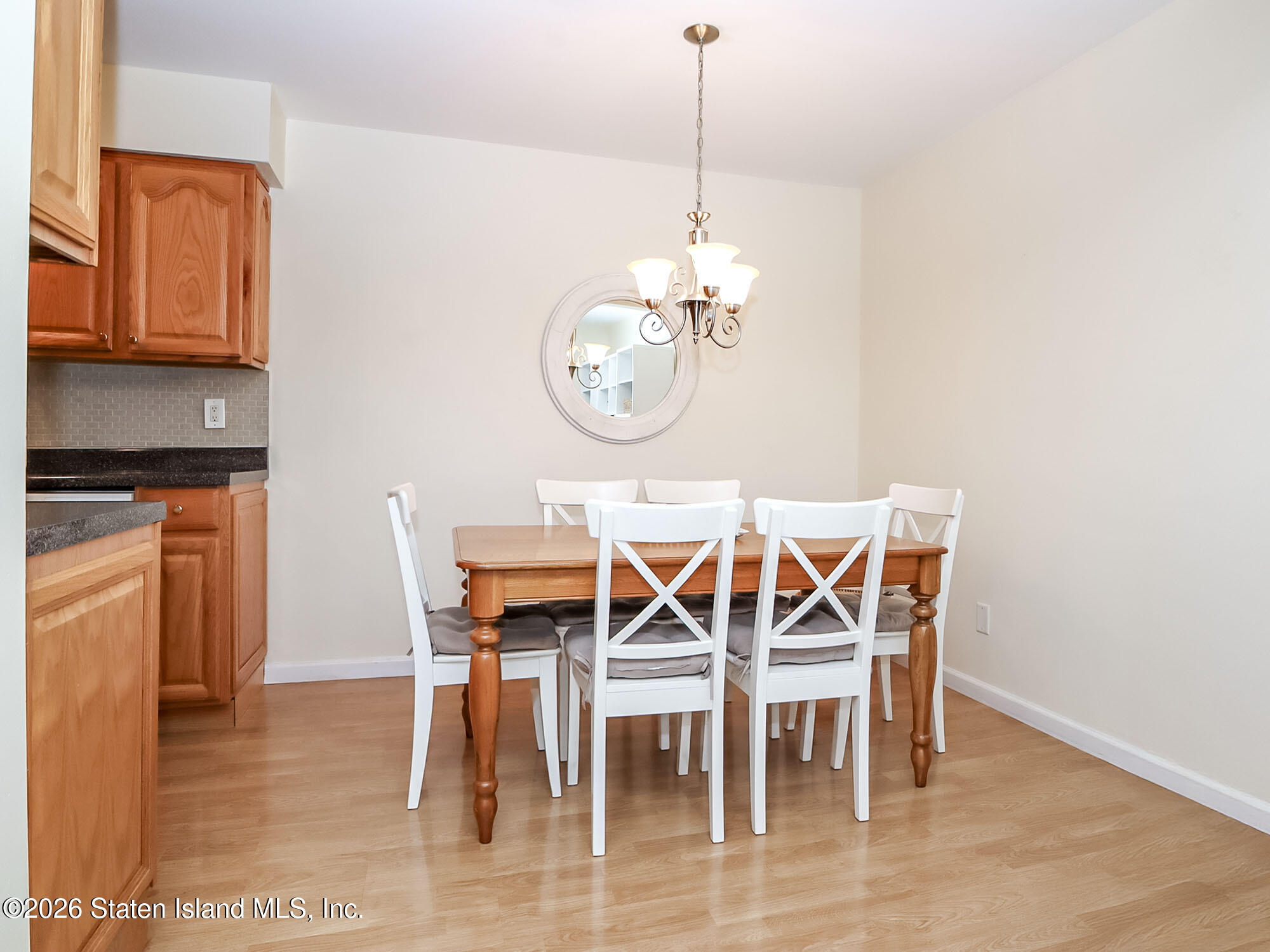 537 Willow Road East, Unit 1 Staten Island, NY 10314 - Photo 10 of 23 a view of a dining room with furniture wooden floor a chandelier