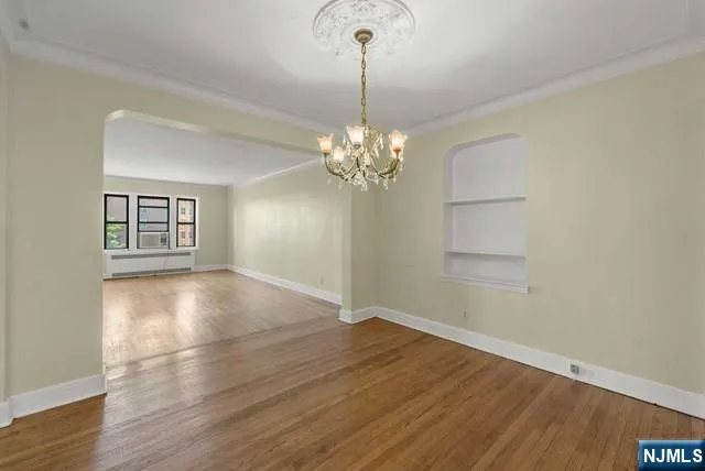 a view of a room with wooden floor and chandelier