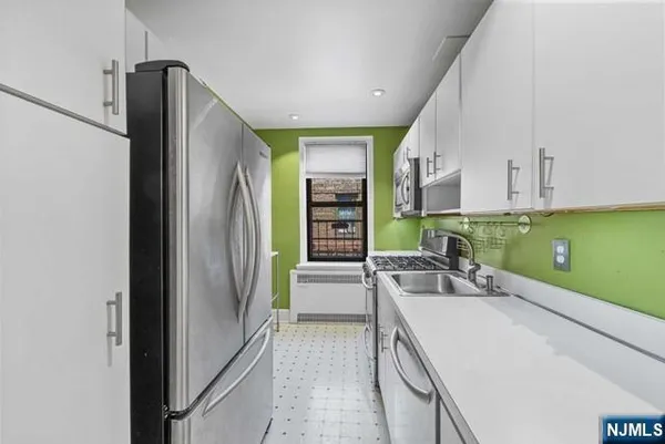 a view of a kitchen with a sink and a refrigerator