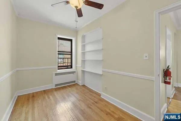 an empty room with a hardwood and ceiling fan