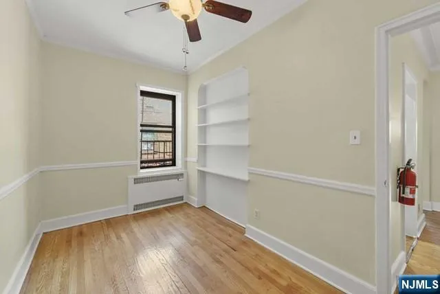 an empty room with a hardwood and ceiling fan