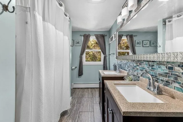 a bathroom with a granite countertop sink a mirror and a shower curtain