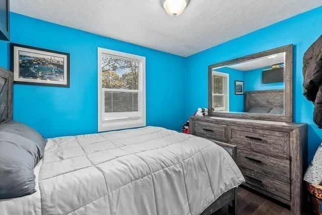 a bedroom with a bed and a large mirror