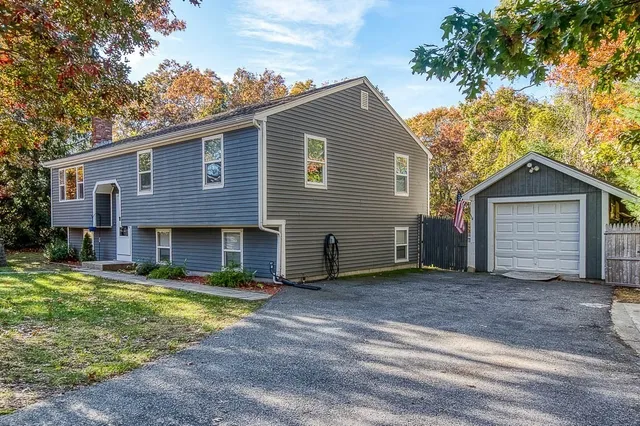 a view of a house with a big yard and large tree
