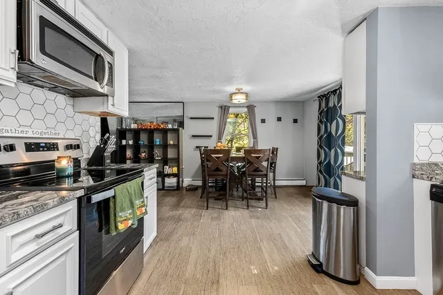 a kitchen with stainless steel appliances a stove a microwave and a hard wood floor