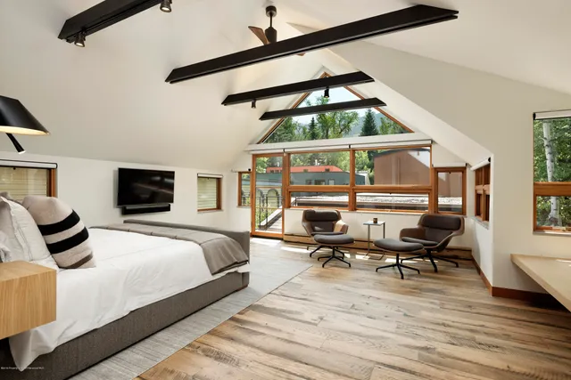 a bedroom with furniture white walls and a window