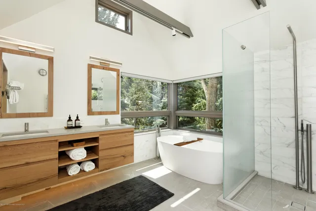 a large white kitchen with a large window and stainless steel appliances