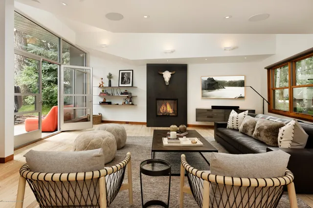 a living room with furniture a fireplace and a large window