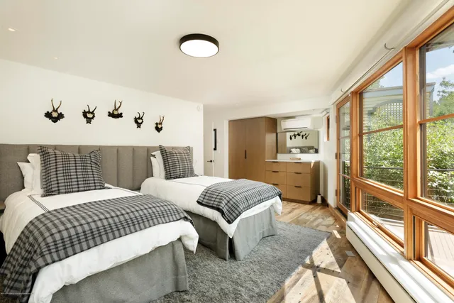 a bedroom with a bed and a large window with outer view