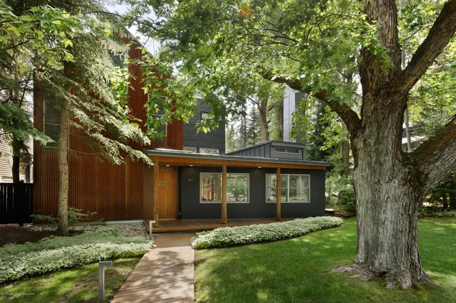 a view of a yard in front of a house with large tree