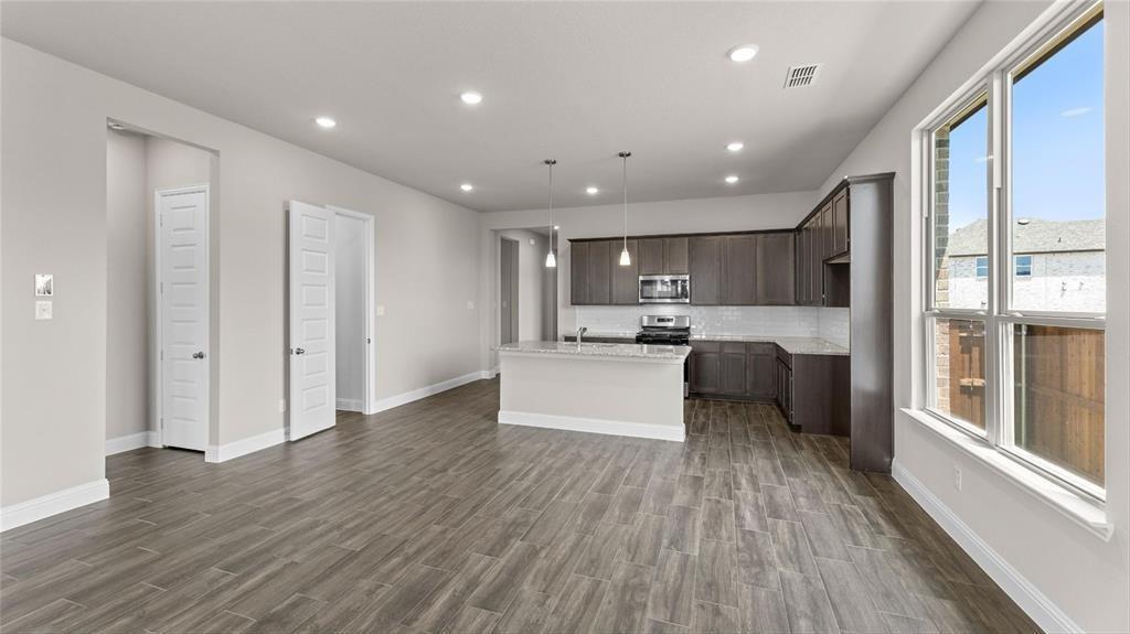 3804 Malibu Drive Sherman, TX 75090 - Photo 14 of 27 a large white kitchen with stainless steel appliances granite countertop a large window and wooden floor