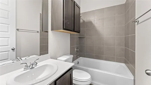 a bathroom with a bathtub shower sink vanity and toilet