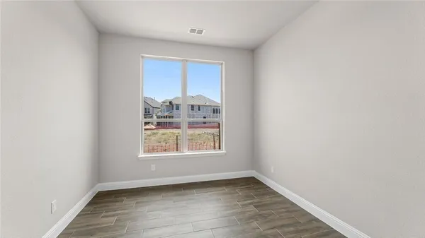an empty room with wooden floor and a window