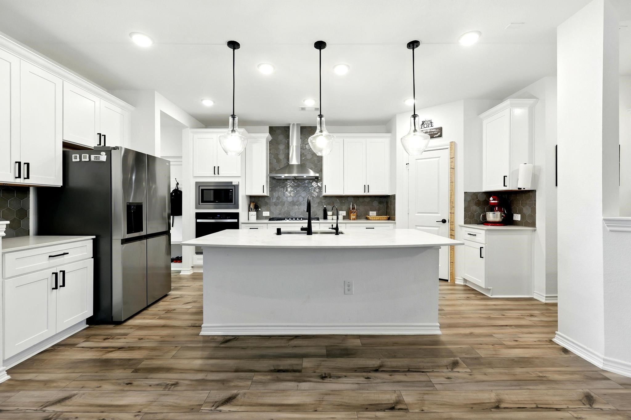 15727 Rosemary Hl Lane Conroe, TX 77302 - Photo 5 of 28 a kitchen with stainless steel appliances kitchen island granite countertop a refrigerator a stove and a sink