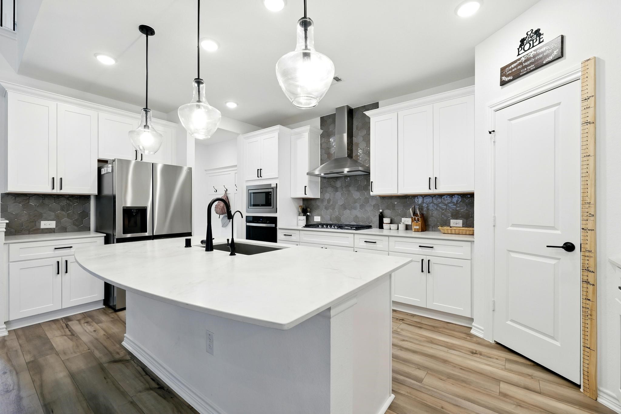 15727 Rosemary Hl Lane Conroe, TX 77302 - Photo 6 of 28 a kitchen with kitchen island a white cabinets and refrigerator