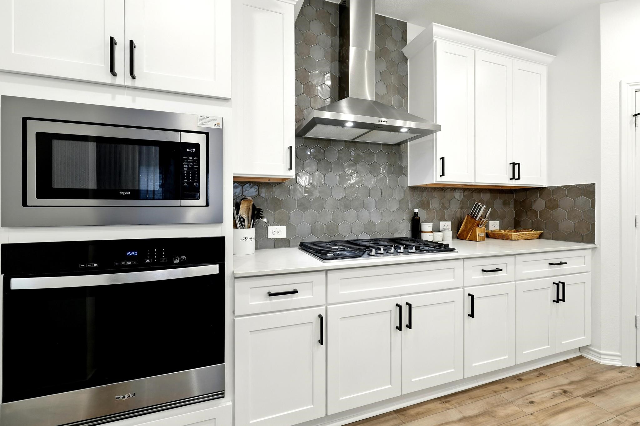15727 Rosemary Hl Lane Conroe, TX 77302 - Photo 9 of 28 a kitchen with stainless steel appliances granite countertop white cabinets and a stove a oven with wooden floor