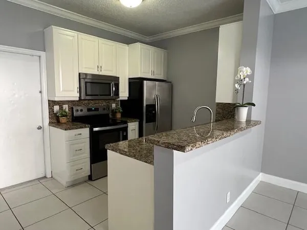 a kitchen with appliances a sink and cabinets
