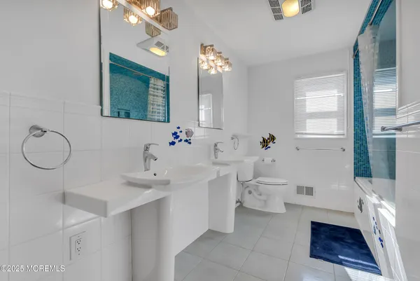 a bathroom with a sink a toilet and a mirror