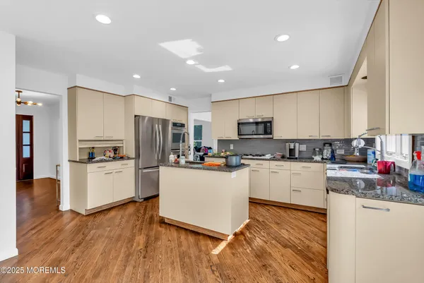 a kitchen with refrigerator a microwave and cabinets