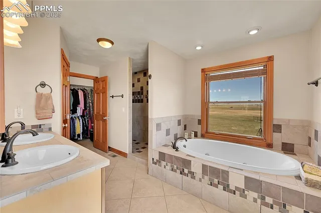 a en suite bathroom with a double vanity sink a mirror and a window