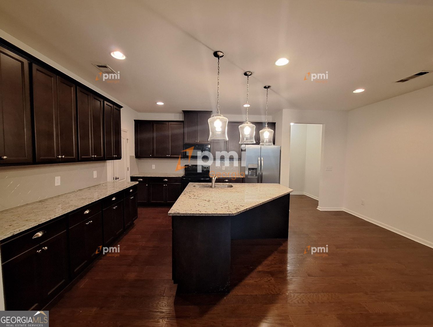 7598 Bucknell Terrace Fairburn, GA 30213 - Photo 2 of 19 a large kitchen with kitchen island a sink dishwasher a stove and a refrigerator with wooden floor