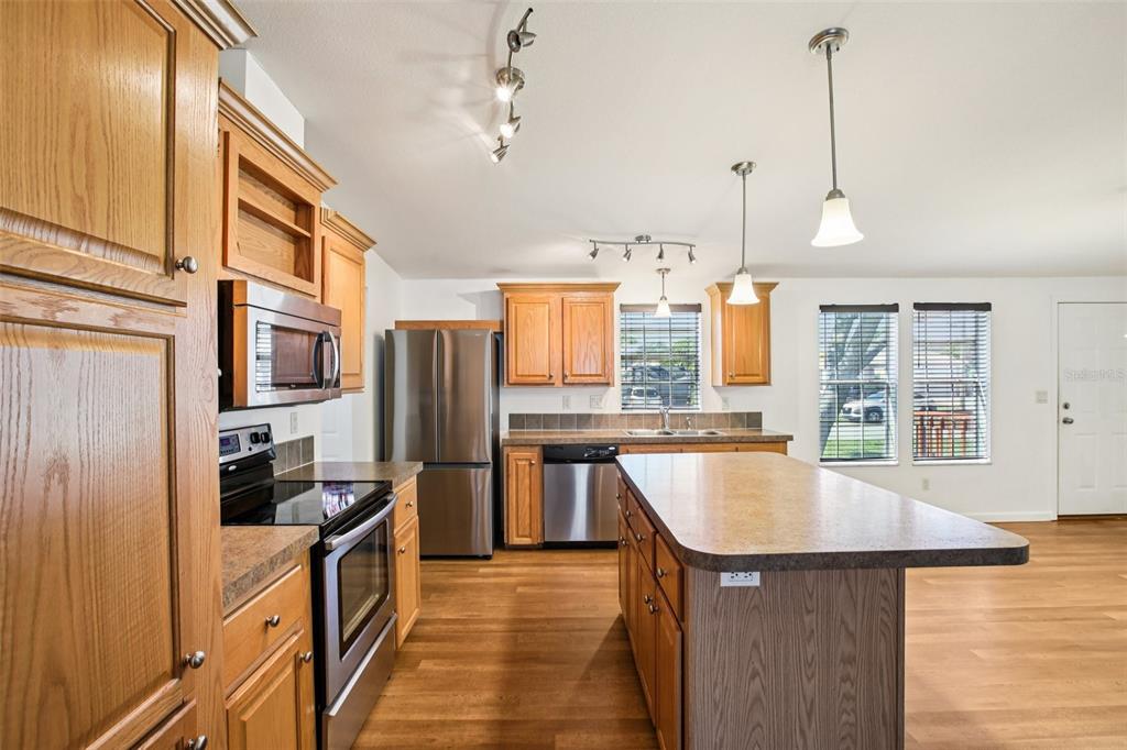 12373 Tree Street Largo, FL 33773 - Photo 11 of 43 a kitchen with stainless steel appliances granite countertop a sink a stove and refrigerator
