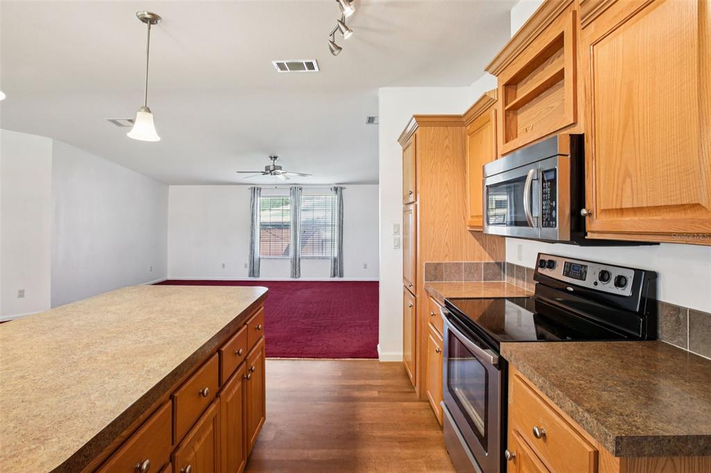 12373 Tree Street Largo, FL 33773 - Photo 13 of 43 a kitchen with granite countertop a stove a sink a refrigerator and wooden floor