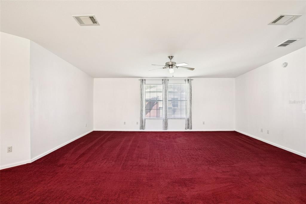 12373 Tree Street Largo, FL 33773 - Photo 20 of 43 an empty room with windows and chandelier fan