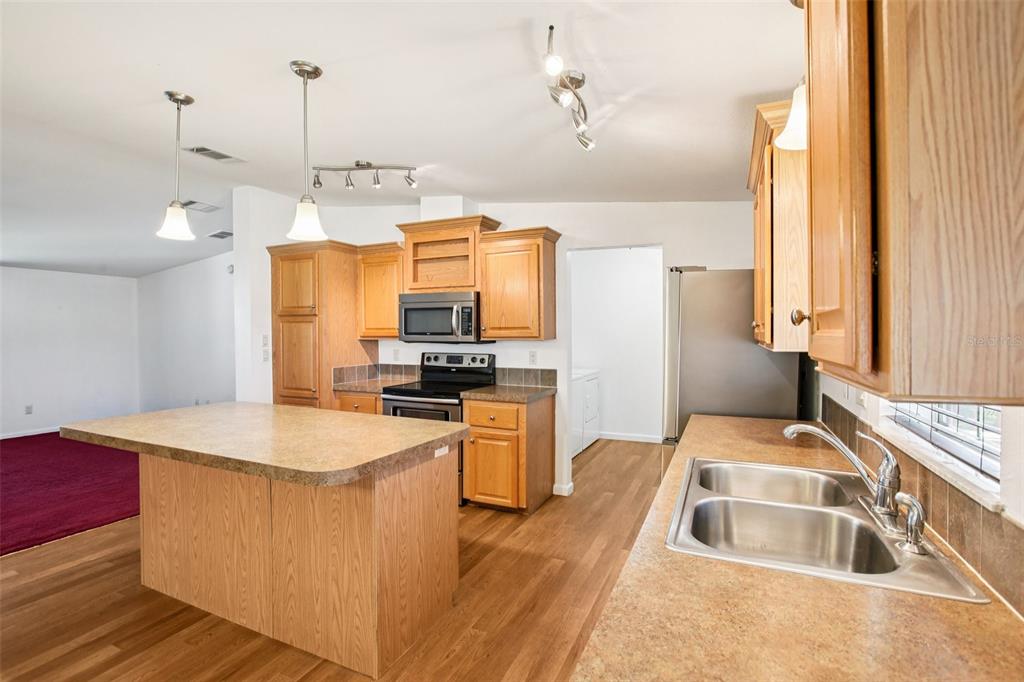 12373 Tree Street Largo, FL 33773 - Photo 10 of 43 a kitchen with a refrigerator sink and stove